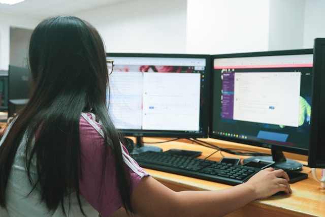 Sekretárka pracujúca na počítači s dvoma monitormi